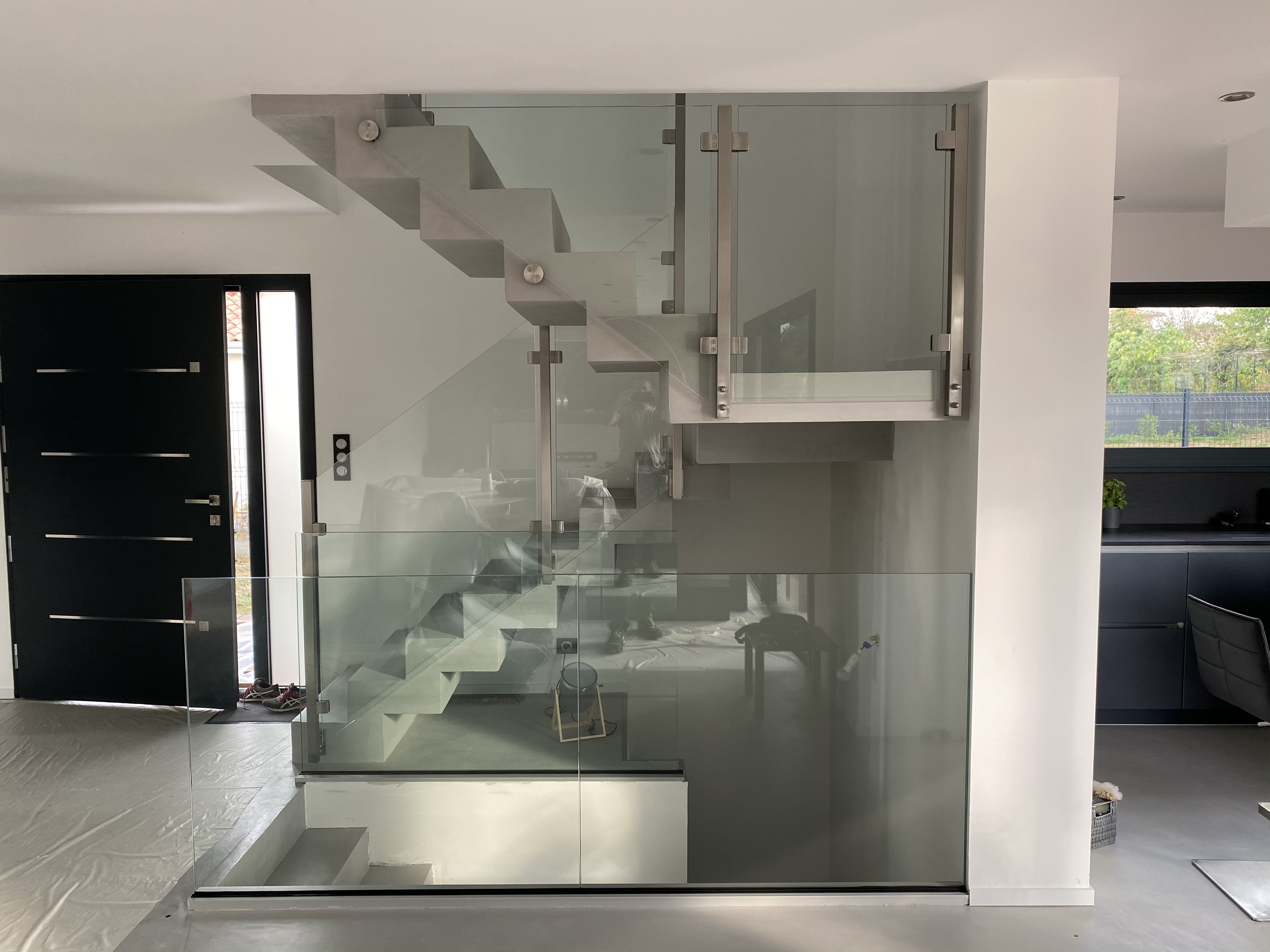 Garde corps en verre sur rail et pince sur un escalier design