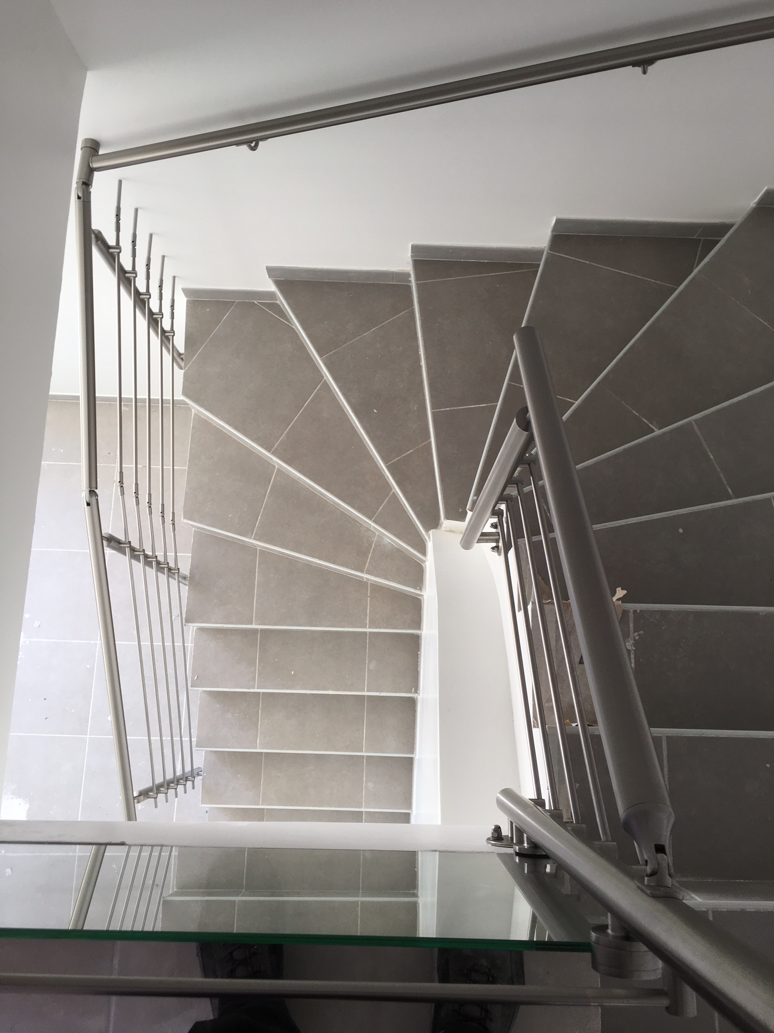 Garde corps et main courante en inox sur un escalier à paillasse carrelé