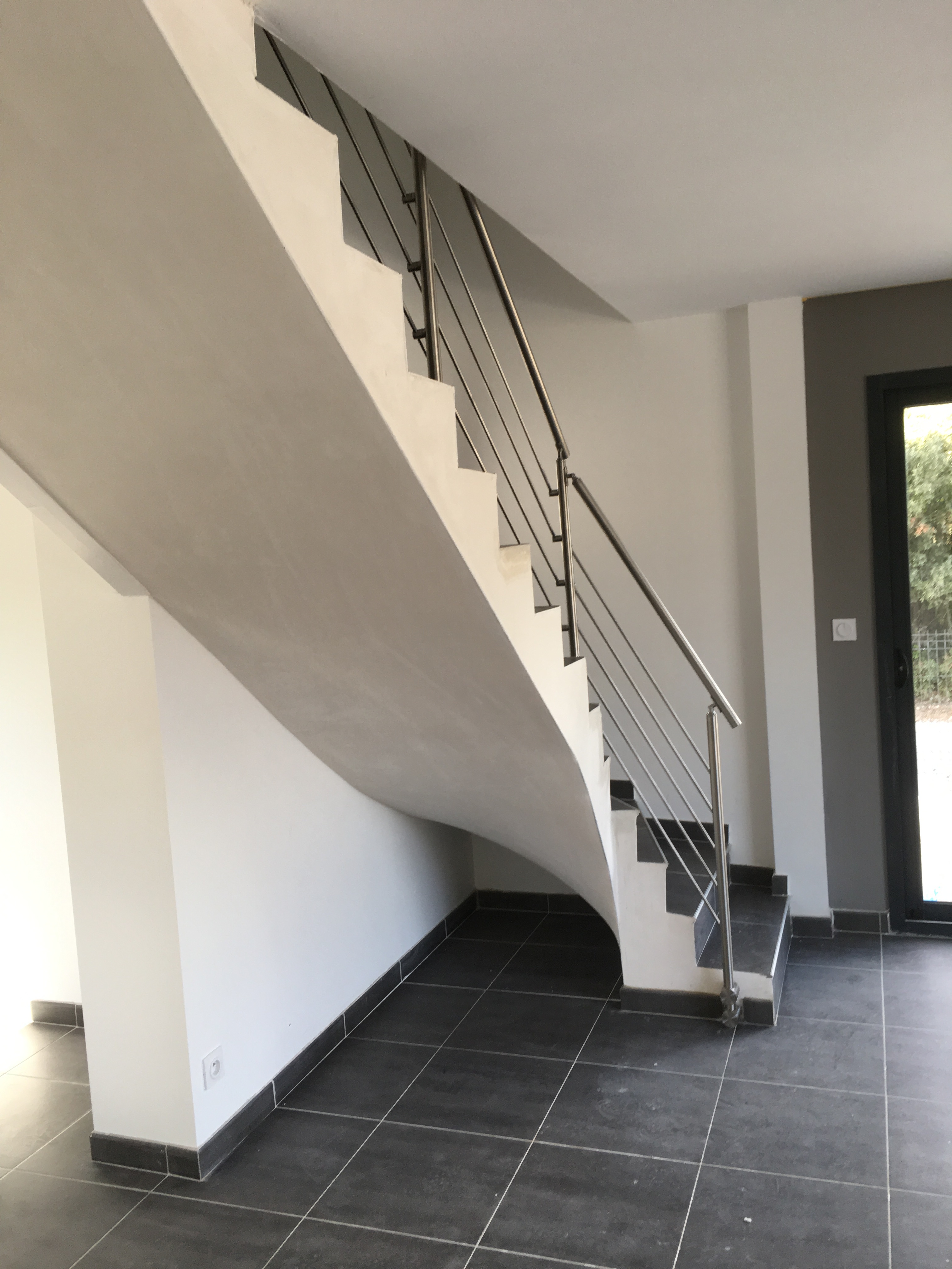Garde corps inox sur un escalier carrelé et plâtré