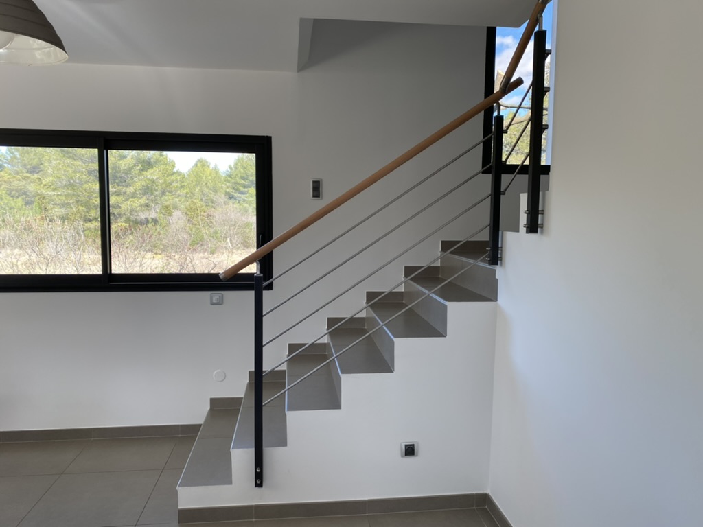 Rambarde en inox et main courante en bois vernis dans une maison située à Montpellier près de la Grande-Motte. Elément incontournable pour votre intérieur.