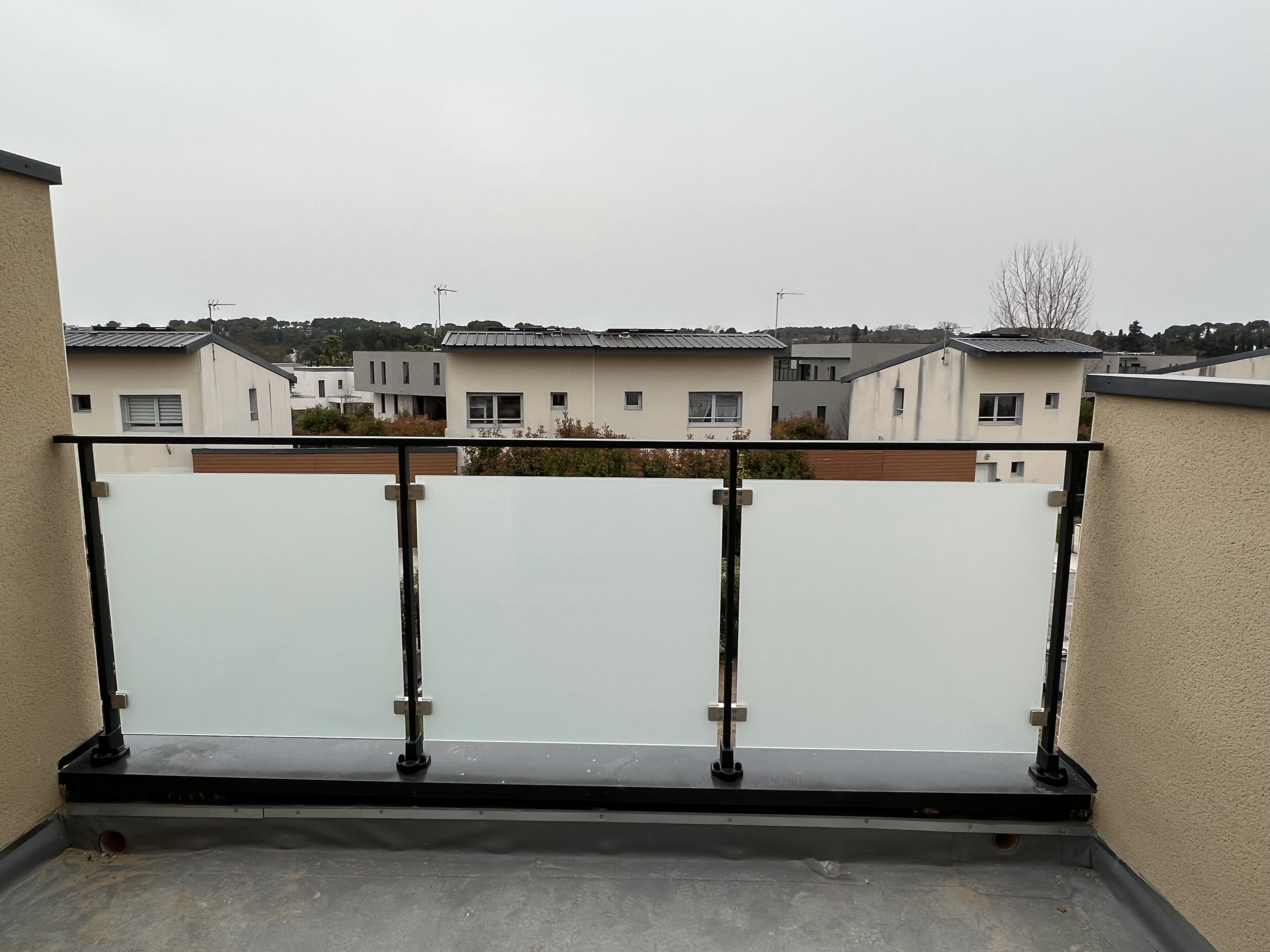 Garde-corps en verre feuilleté 9mm, teinte opale fixé sur des pinces en inox, dans une habitation, en région Occitanie.