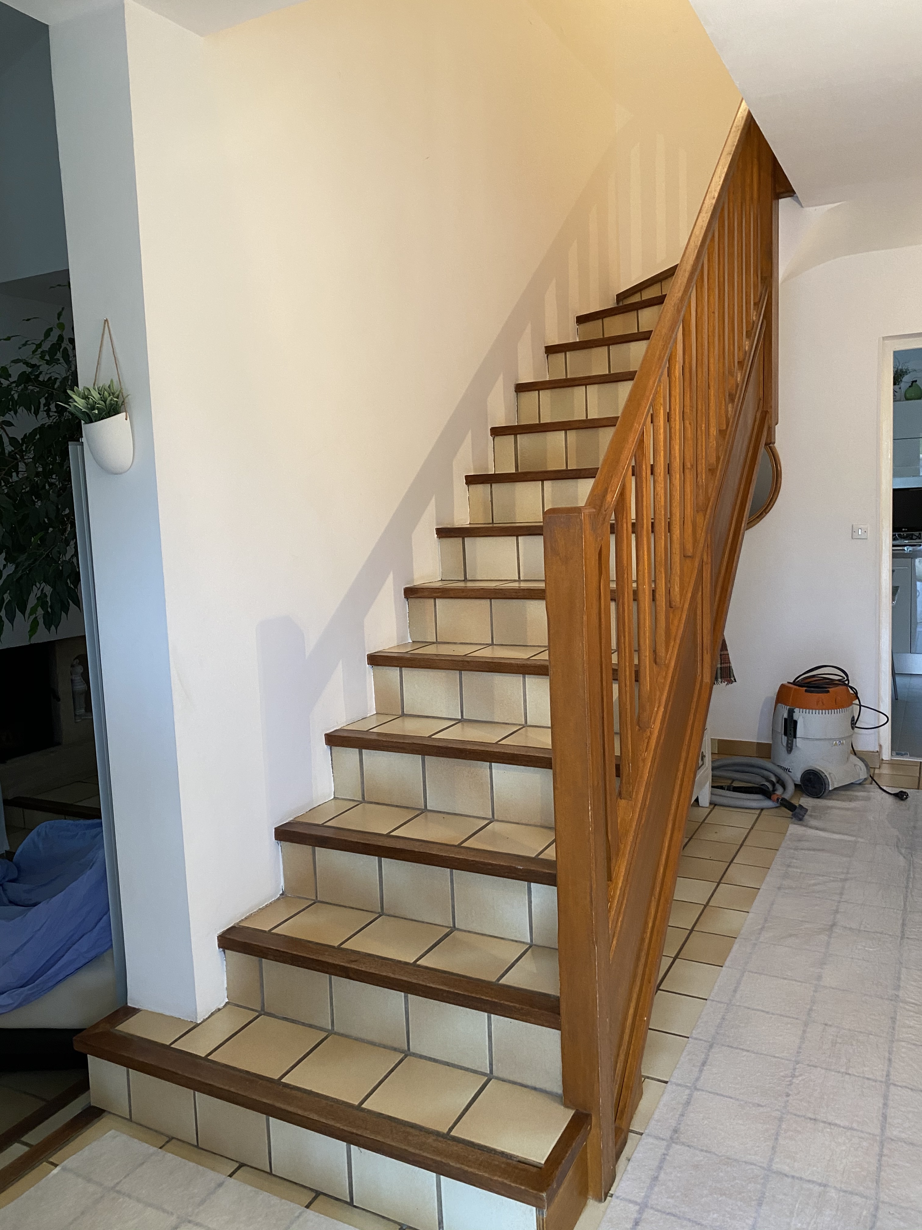 Rambarde en bois sur un escalier en carrelage, remplacée par un garde-corps en inox, dans le département de l'Hérault.