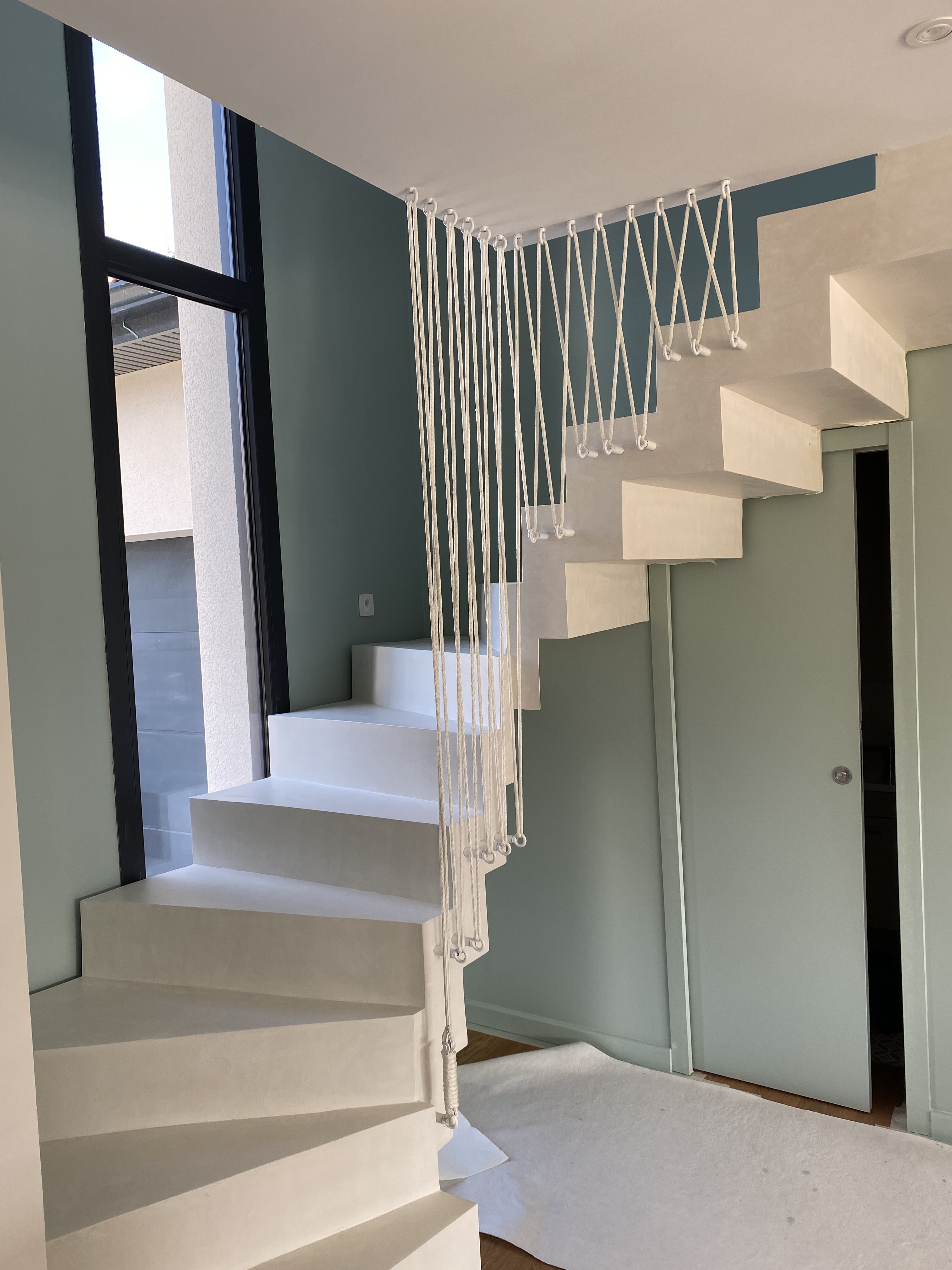 Elément décoratif original fixé sur la joue de la crémaillère, et repris dans une poutre en béton au plafond, dans un logement à Lyon près de Saint-Priest et Vienne.