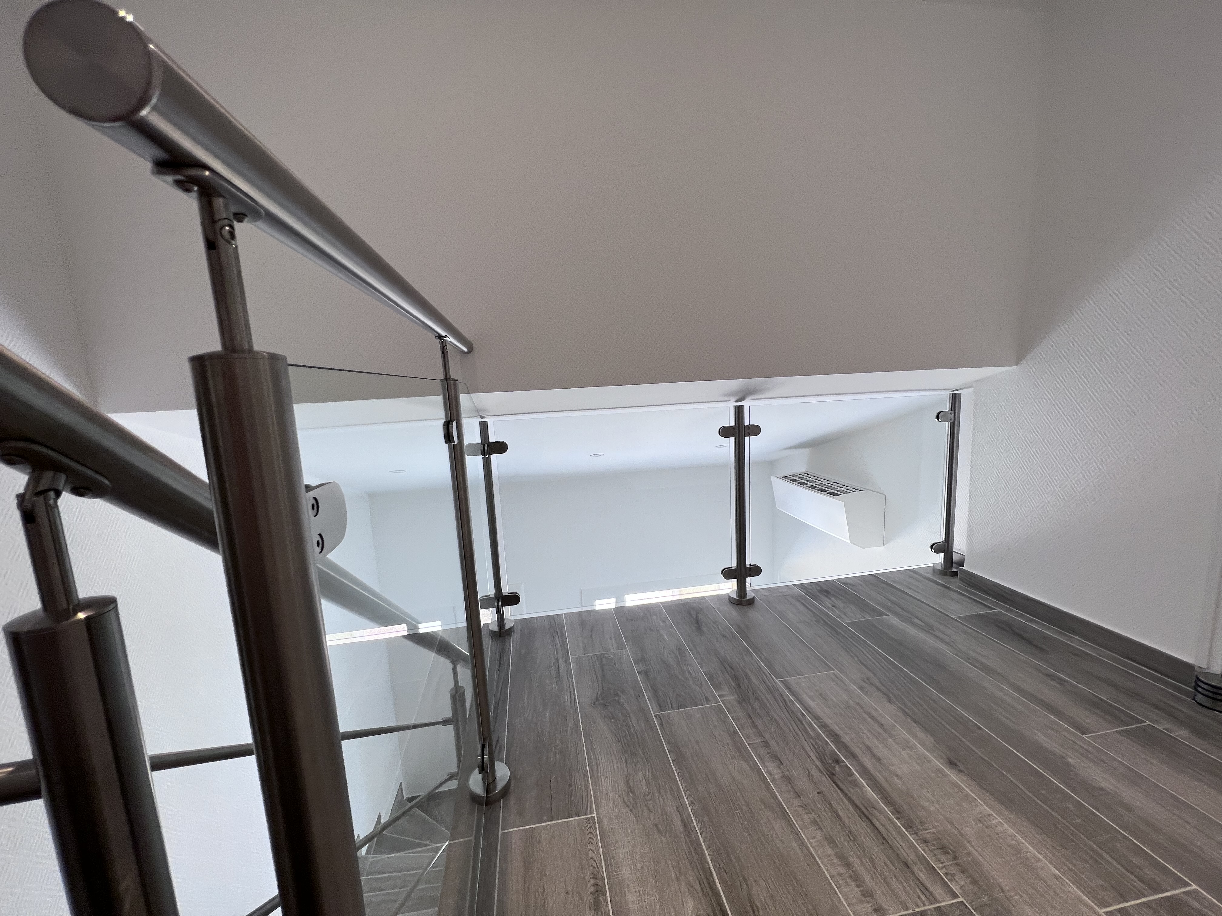 Modèle emblématique d'un verre plein sur palier posé à la française, dans une maison moderne, en région Occitanie.