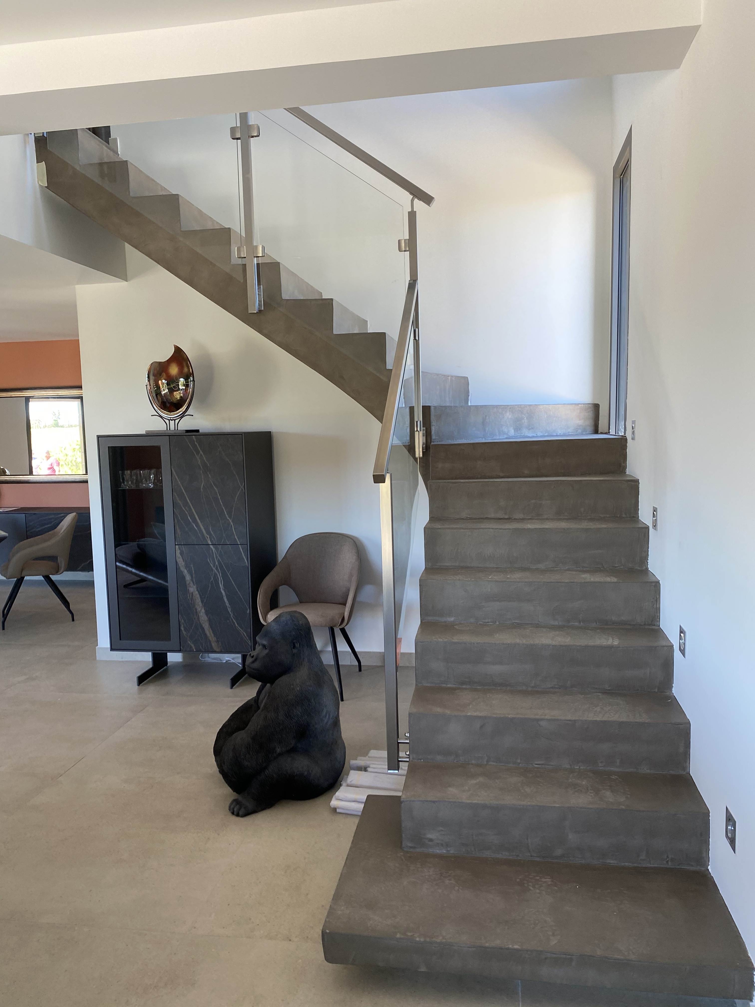 Modèle original d'une balustrade en verre, avec poteaux carrés et main courante en inox, posée sur un escalier à paillasse, en Belgique près de Lille et Calais.