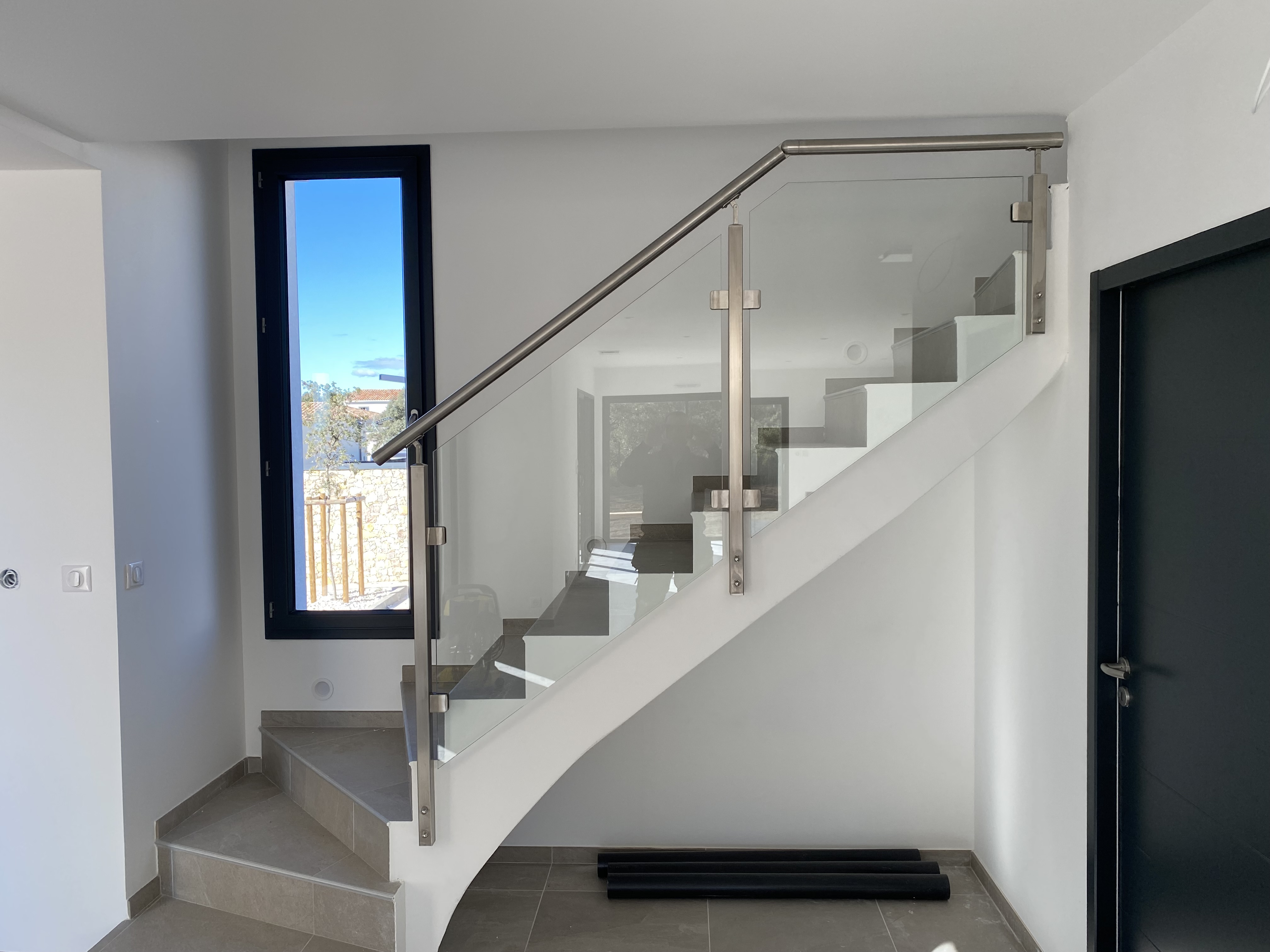 Minimalisme d'un garde-corps en verre posé à l'anglaise sur un escalier à paillasse, à Sausset-les-Pins entre Carry-le-Rouet et Port-de-Bouc.