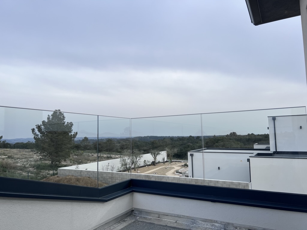 Transparence et vue dégagée par la pose d'un garde-corps en verre, installée dans une terrasse agréable à Nîmes près du Gard.