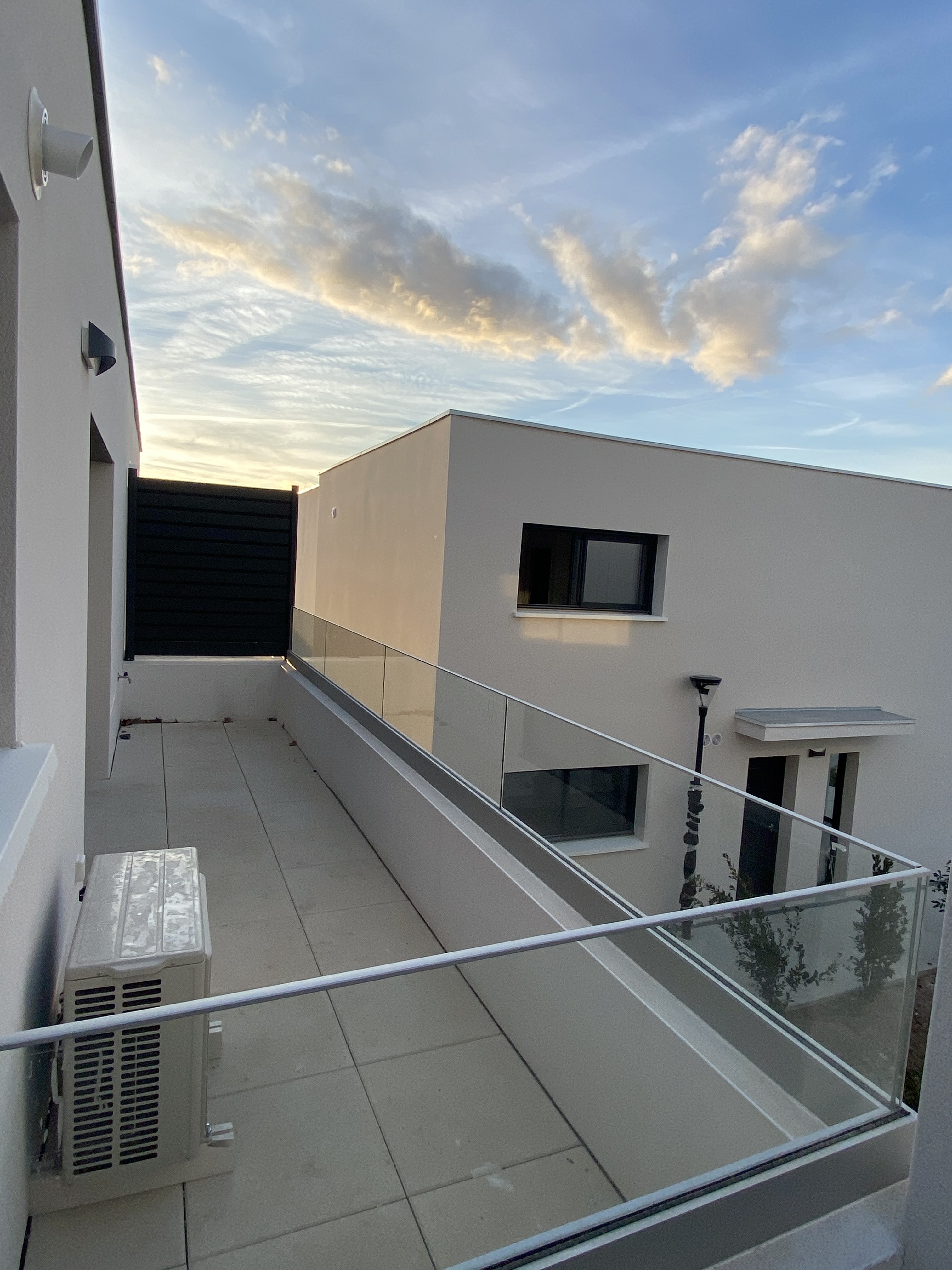 Garde-fou original posé à la française, dans une terrasse, en région Occitanie. Les garde-corps en verre sont un choix populaire pour les maisons modernes en raison de leur apparence élégante et de leur transparence.