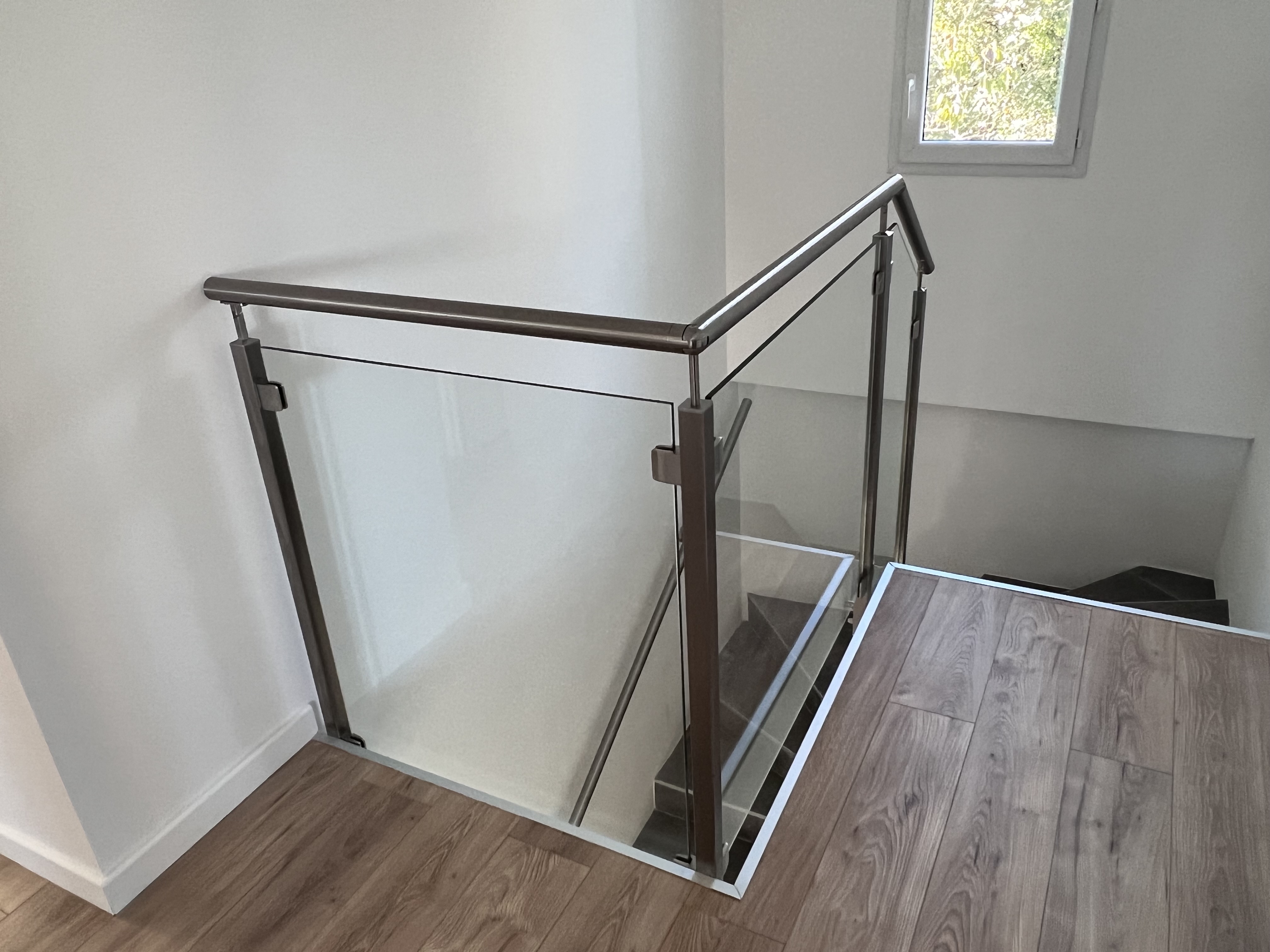 Balustrade disposant d'une installation à l'anglaise, combinant habilement des matériaux en verre et en inox pour une merveilleuse esthétique.