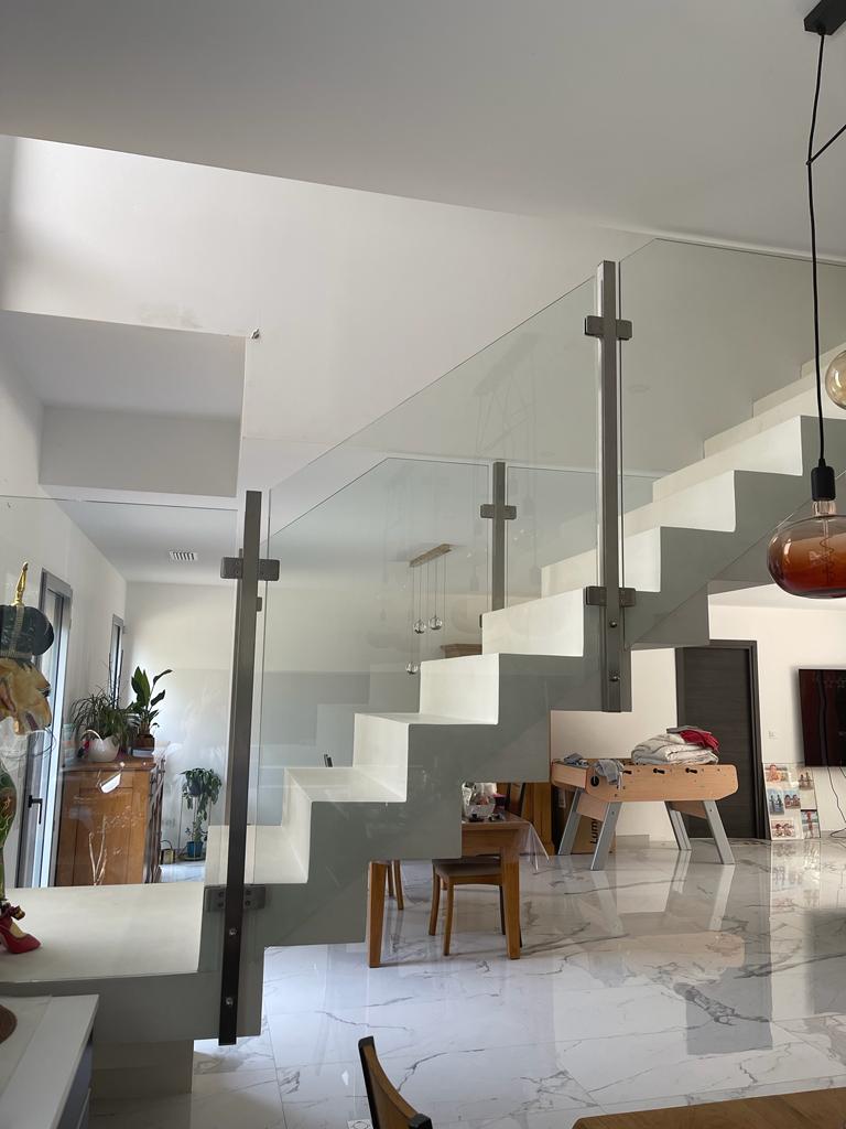 Balustrade en verre posée sur un escalier à crémaillère.