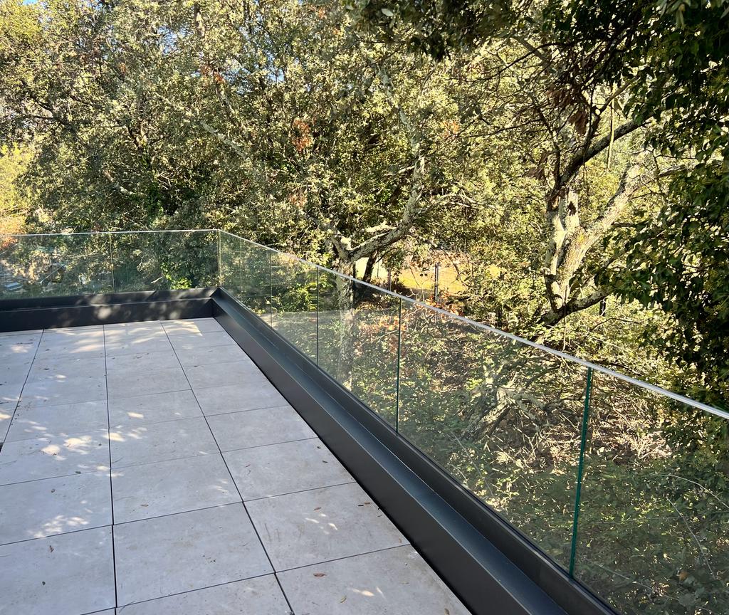 Garde-corps minimaliste en verre, posé sur une magnifique terrasse d'une villa, située en région Occitanie.